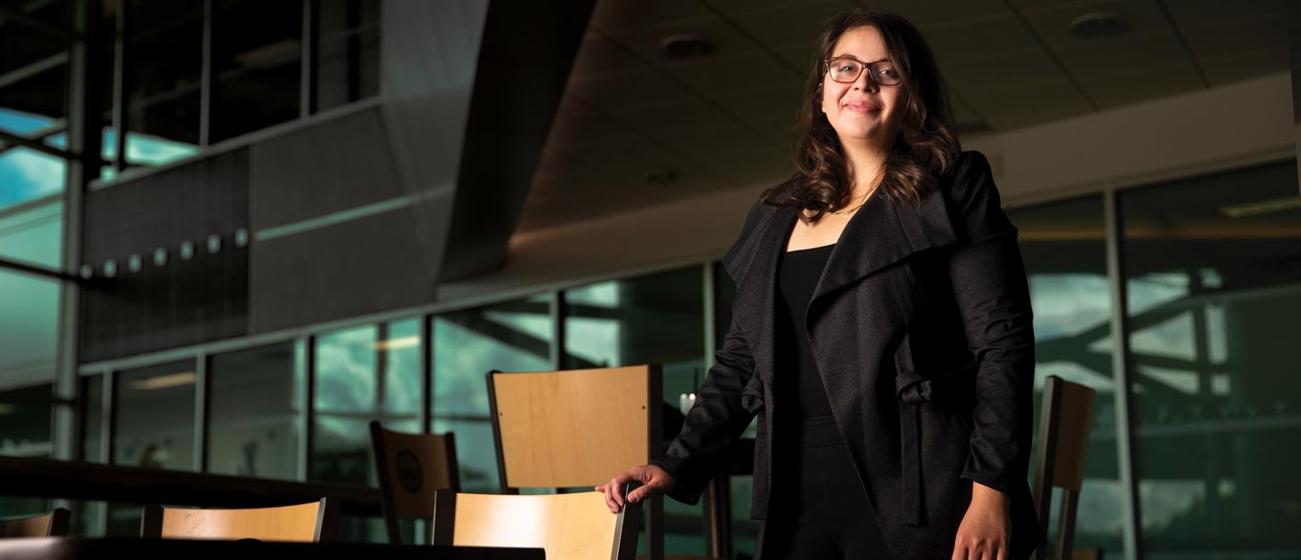 Image of a college aged girl standing and smiling at the camera